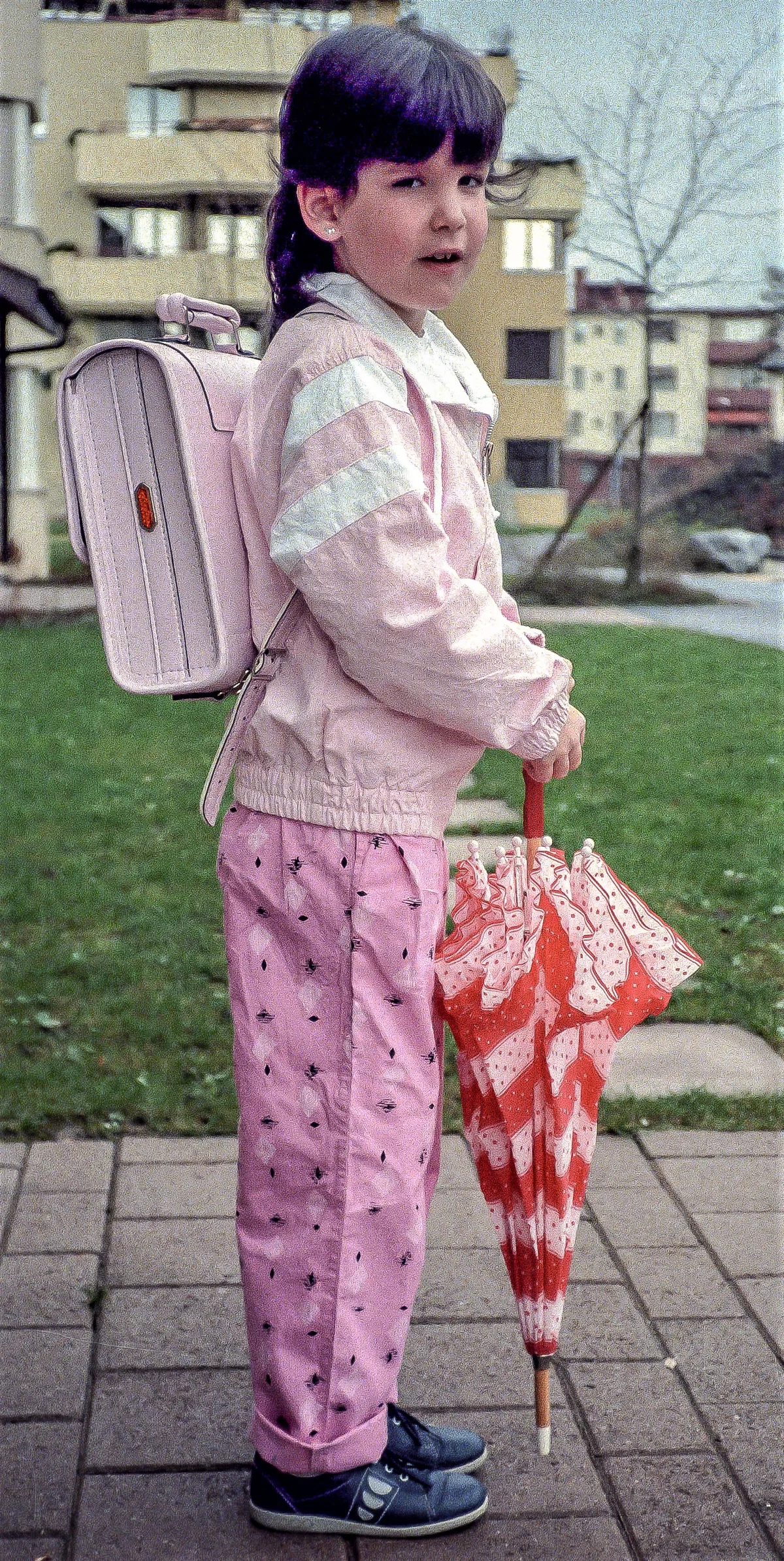 Man sieht ein Mädchen an seinem ersten Schultag.
